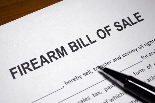 black pen placed on top of a 'firearm bill of sale' document