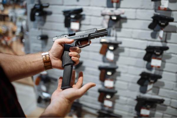 man examining a handgun at a gun shop