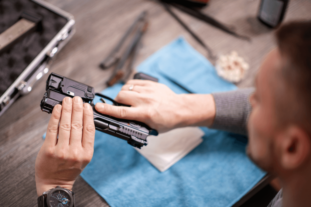 Man reassembling his gun after cleaning it
