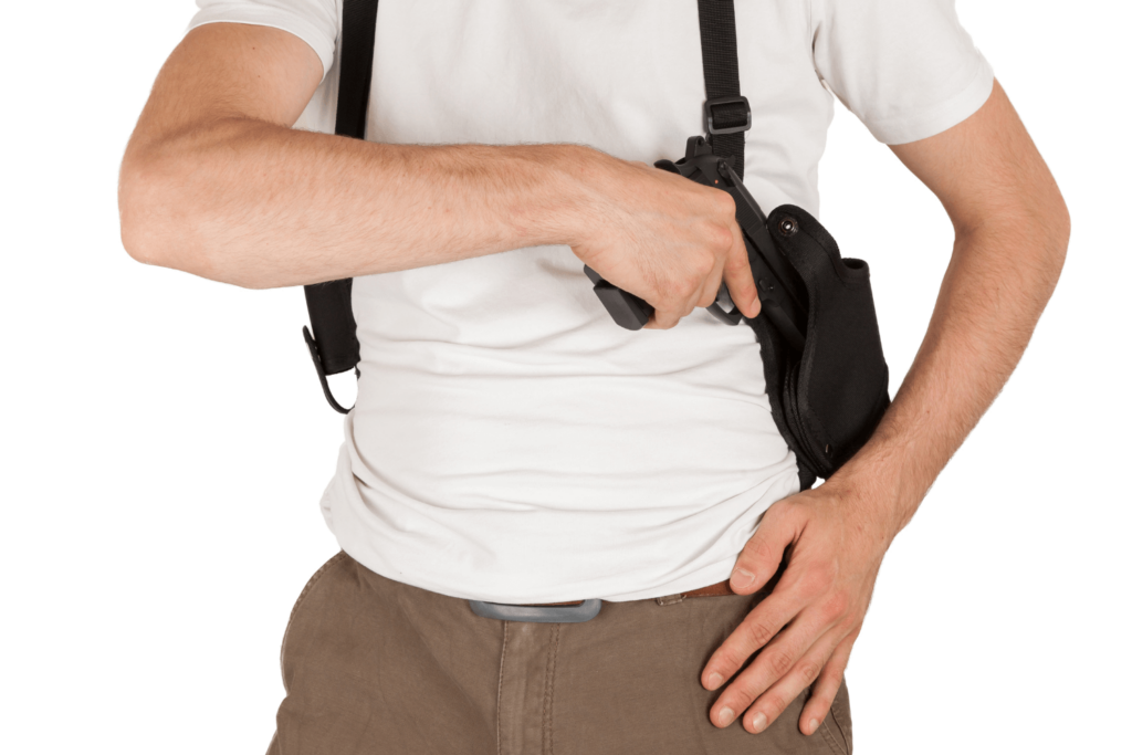 Man drawing a firearm from his shoulder holster
