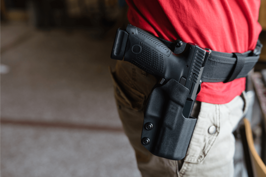 Man Wearing a Tactical Belt with a Gun Secured in a Holster on His Hip