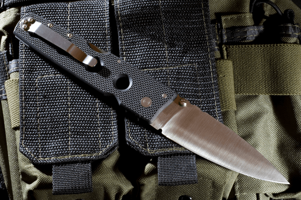 Tactical Folding Knife Placed on Top of Nylon Gear