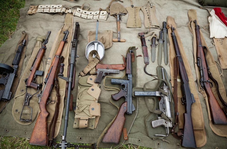 A collection of WWII rifles, pistols, and machine guns