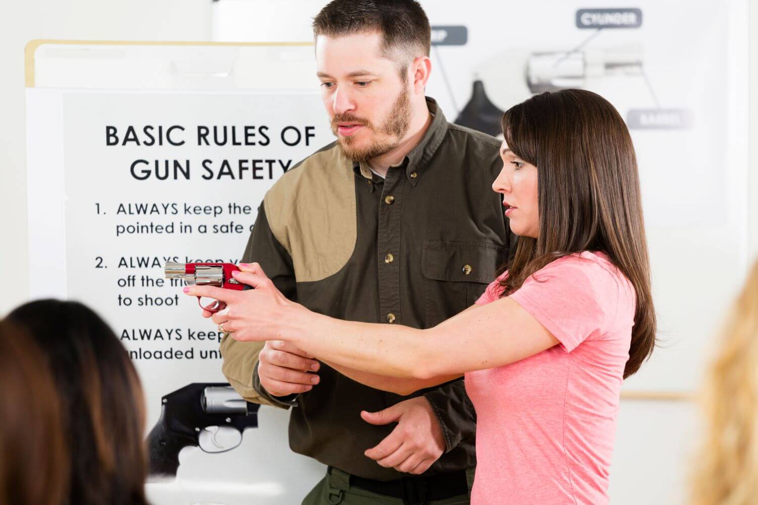 Woman learning how to aim a firearm at a gun safety class