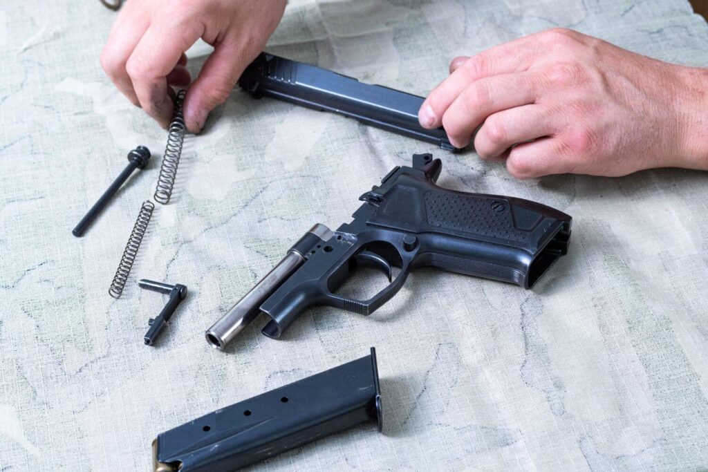 A disassembled pistol laying on top of a white cloth
