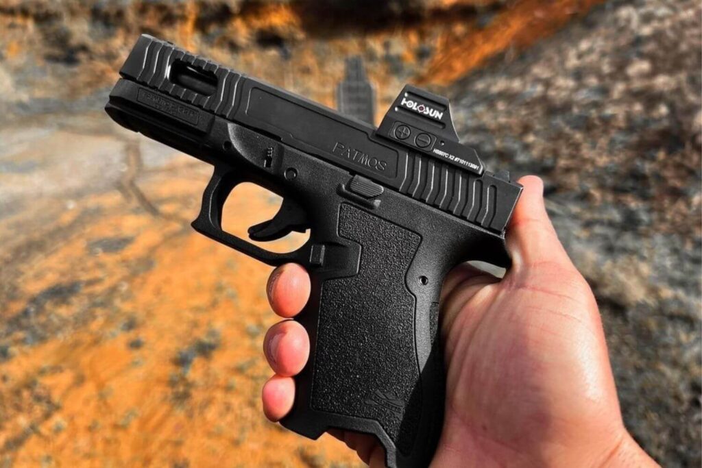 Hand Holding a Black Custom Pistol with Various Aftermarket Parts