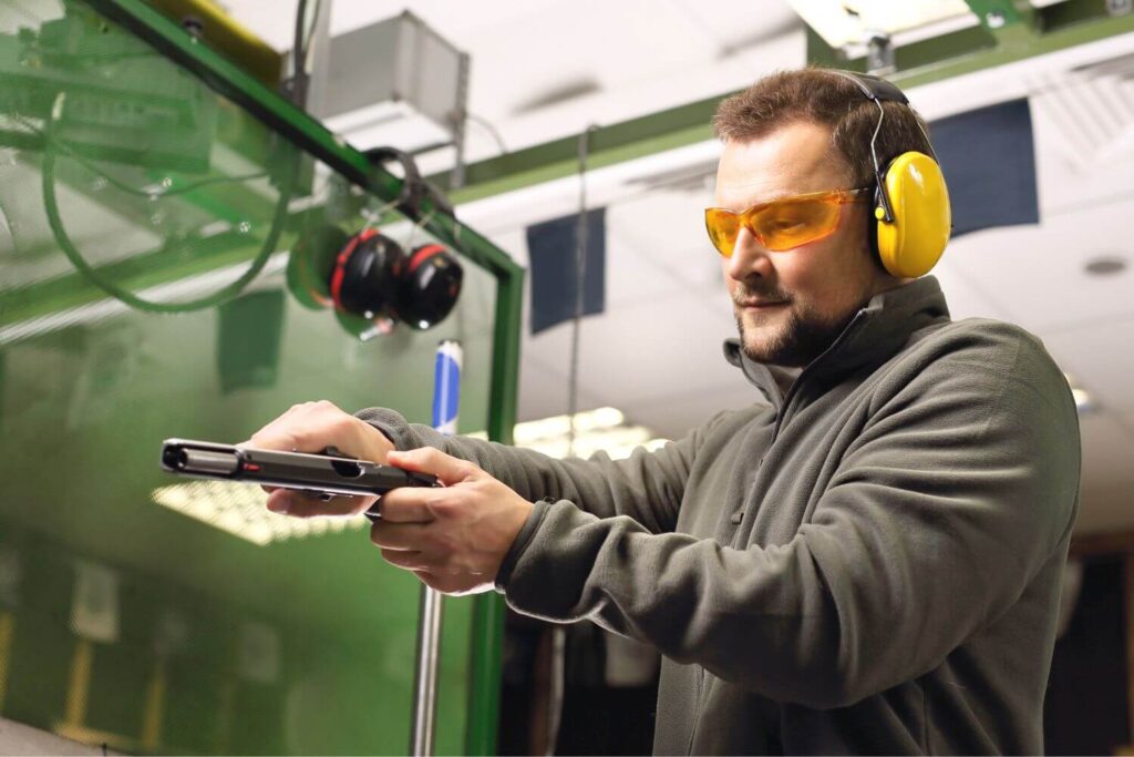 Man Wearing Protective Eye and Earwear Reloading His Pistol at an Indoor Shooting Range