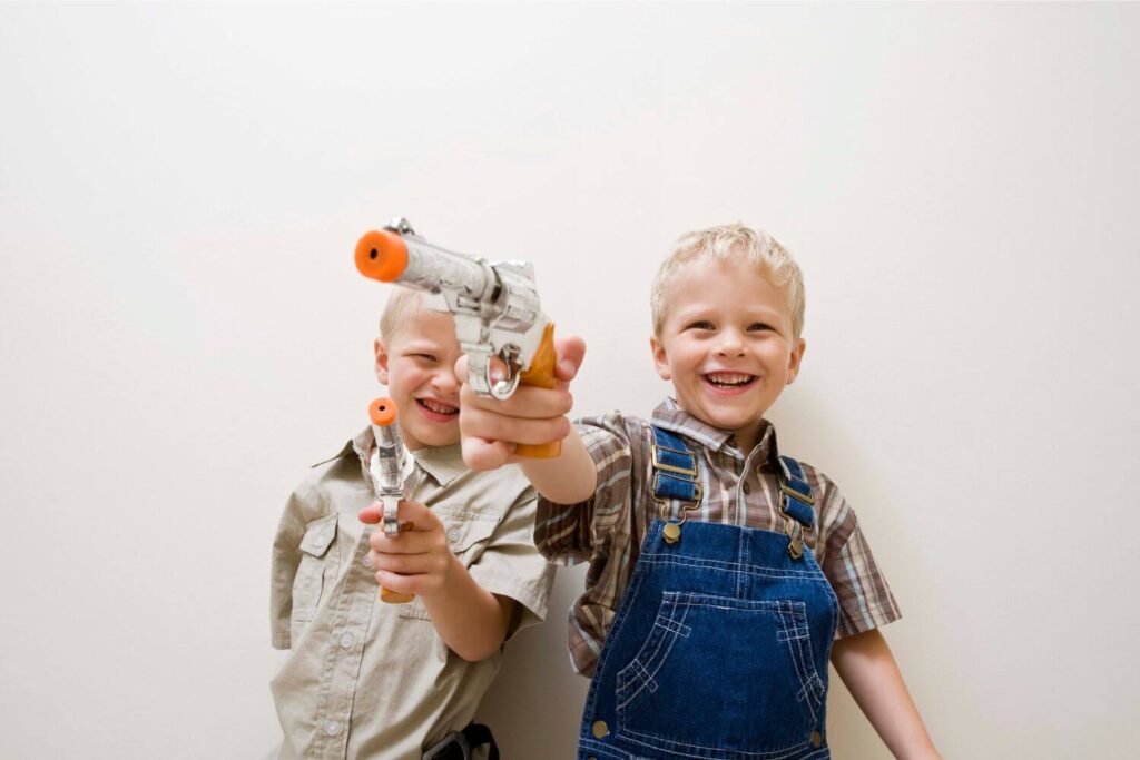 Two Young Boys Holding Toy Guns