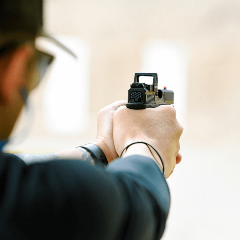 man wearing protective gear while firing a gun with an optic mounted - Pennsylvania Gun Shows | Get Tickets For Eagle Shows Man Wearing Protective Gear While Firing a Gun with an Optic Mounted