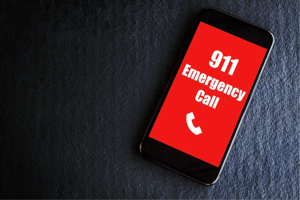 A cell phone on a table with a red screen that says 911 Emergency call - Pennsylvania Gun Shows | Get Tickets For Eagle Shows a Cell Phone on a Table with a Red Screen That Says 911 Emergency Call