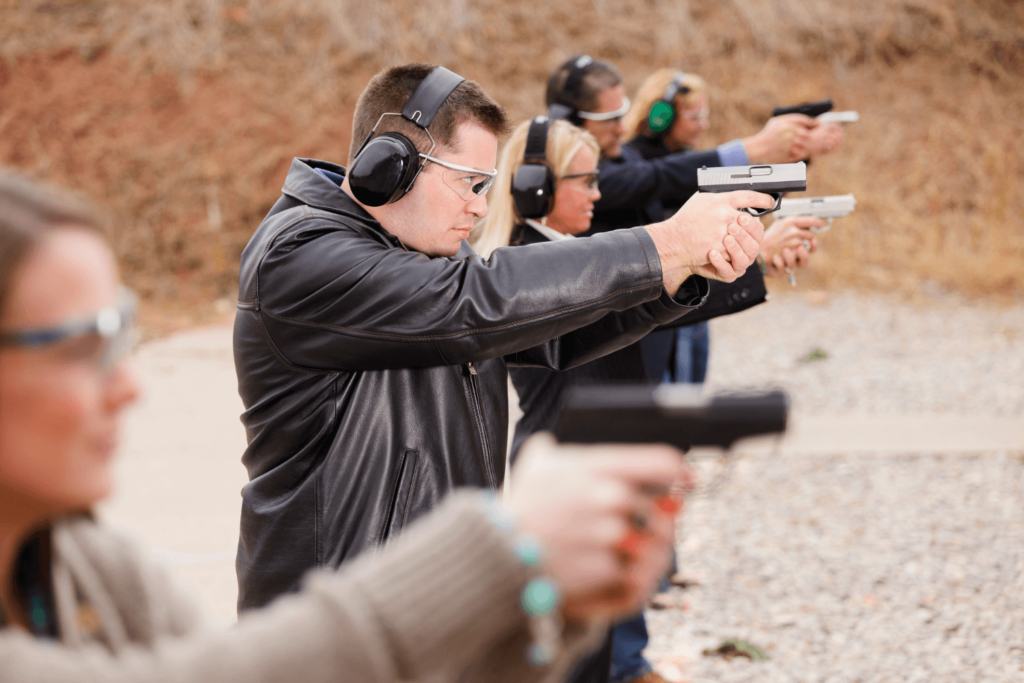 A group of men and women standing next to each other holding a gun and wearing protective ear coverings - Pennsylvania Gun Shows | Get Tickets For Eagle Shows a Group of Men and Women Standing Next to Each Other Holding a Gun and Wearing Protective Ear Coverings