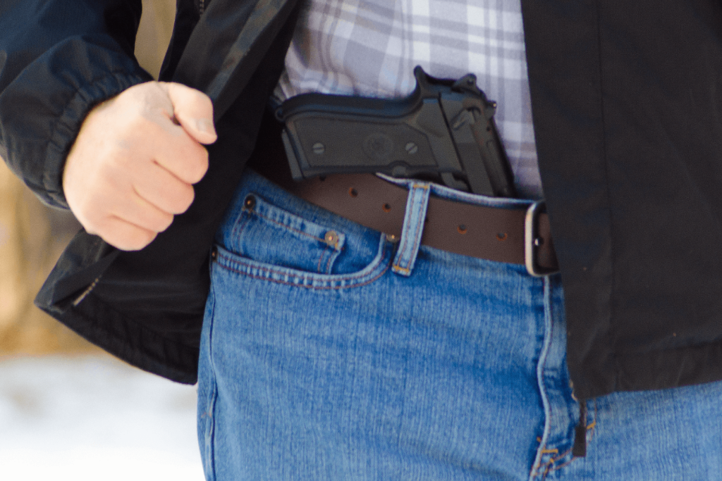 a Man Wearing Jeans with a Belt and a Gun Tucked into His Waistband