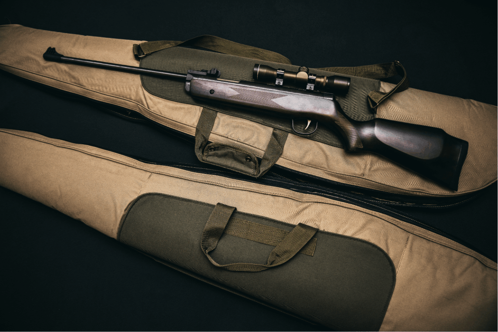 a Large Rifle Placed on Top of a Soft Fabric Carrying Case with Handles