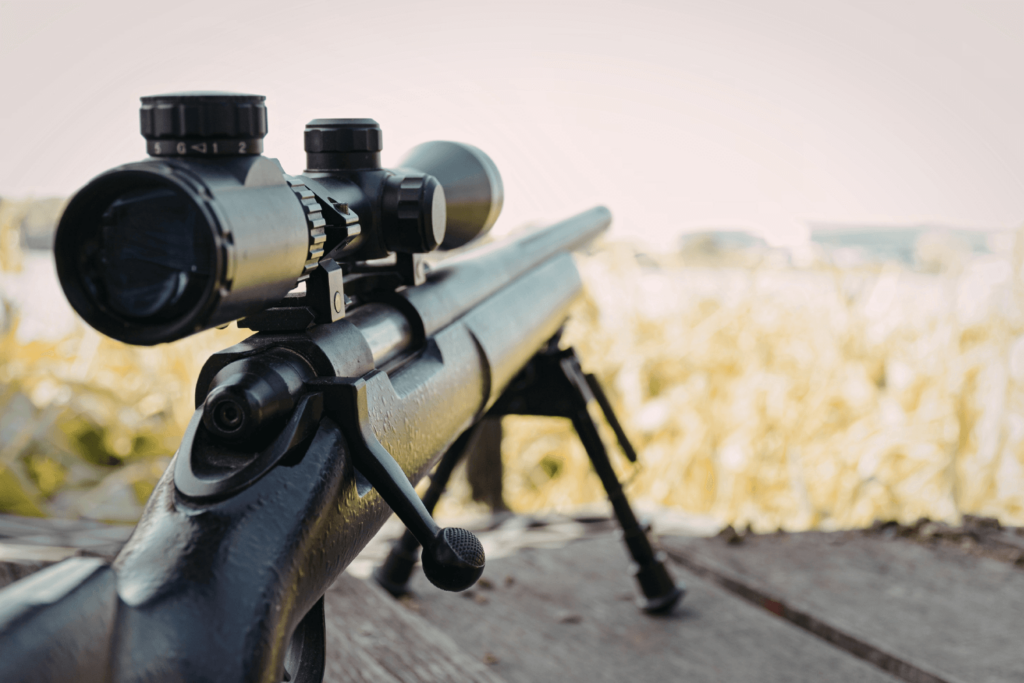 a Rifle with a Large Scope Attached Pointed out Towards a Field