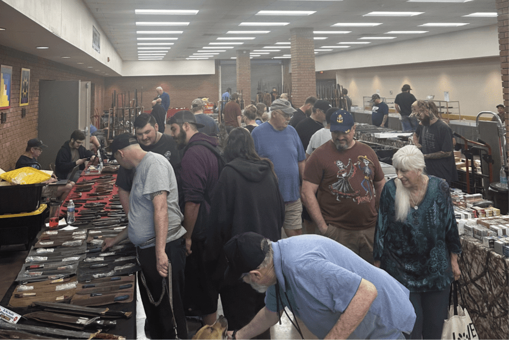 a Gun Show with Tables Set Up and Different People Shopping Around