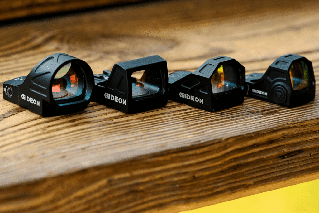 Lineup of 4 Various Gideon Optics Red Dot Models on a Wooden Shelf