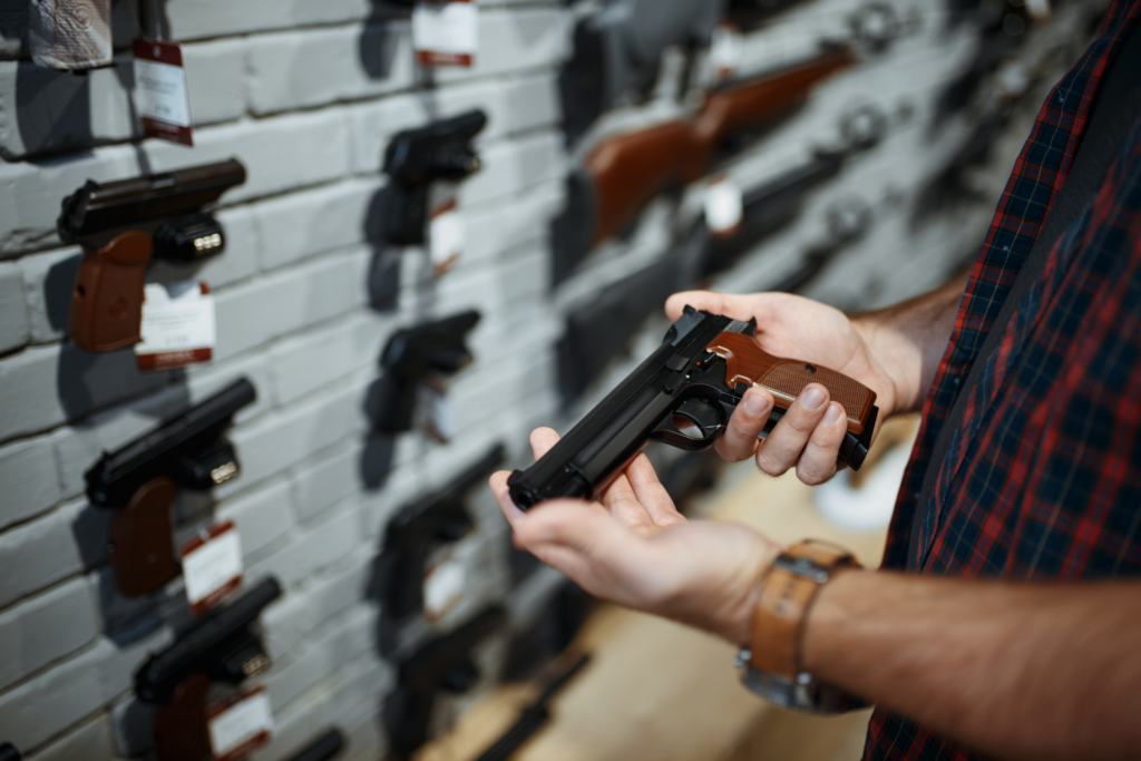 Man Holding a Firearm As He Browses Different Brands and Models